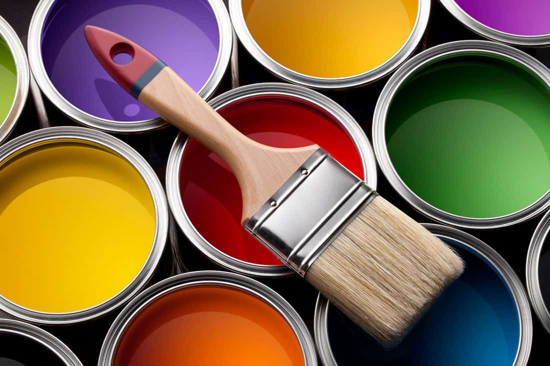 Colorful latex and enamel paint cans with brush